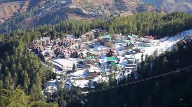 Çam ormanı ve karla çevrili uzak tepe yerleşkesi