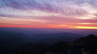 Sisli dağ manzarasının üzerinde dramatik bir akşam gökyüzü