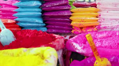 Hindistan 'da festival sezonunda market tezgahlarına istiflenmiş renkli holi tozu paketleri