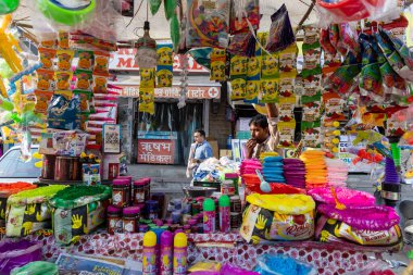 Holi, renkli pudralar ve dekoratif festival oyuncaklarıyla dolu bir sokak tezgahı.