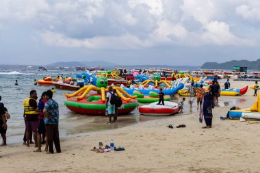Kalabalık tropikal plajlar, şişirilebilir su yolculukları ve deniz kenarındaki aktivitelerden keyif alan turistler 01 Aralık 2025 'te Andaman Hindistan' daki Fil Sahili Havelock Adası 'nda (Swaraj Dweep) çekildi..