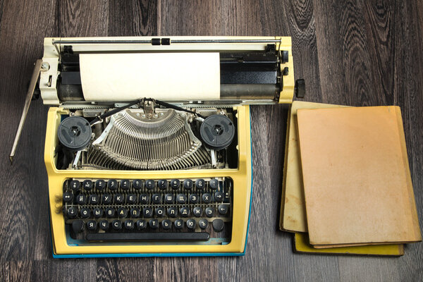 пишущая машинка и стопка книг рядом
