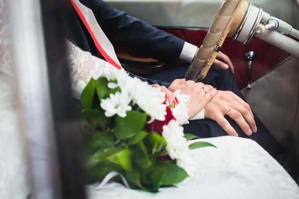 Mains jeunes mariés dans une voiture avec une faible profondeur de champ — Photo