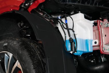 Depoda çamaşır deterjanı ve arabada bir motor var.