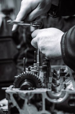 İçten yanmalı motorun kam mili ve eldivenli bir işçi eli ve sığ bir alan ayarlaması.