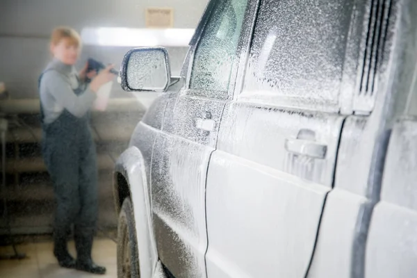 Aplicación de una solución de espuma a un coche a poca profundidad de campo — Foto de Stock