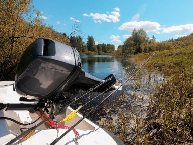 bir teknede motorun dışında ve nehir ve gökyüzünün arka planında dönen çubuklar.
