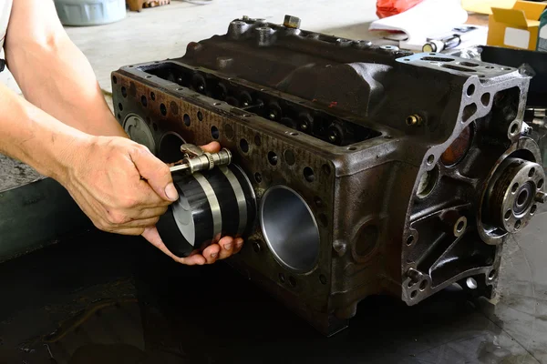 Mechanic is wearing Pistons — Stock Photo, Image