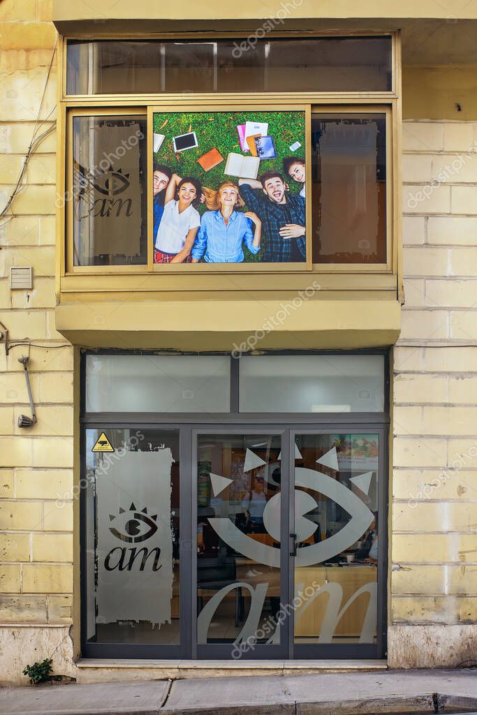 Sliema, Malta - 11.03.2025:  Front view of a modern language school with logo on glass doors and a banner of happy students above.