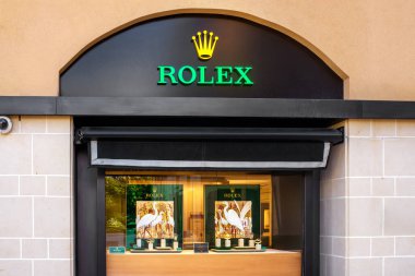San Giljan, Malta - 11.11.2025: Storefront and sign of the luxury watch retailer Rolex with a glass window display featuring watches and a graphic image of egrets.