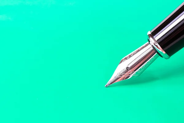 Фонтанная ручка на зеленом фоне с дорожкой обрезки — стоковое фото