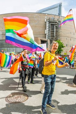 Oslo, Norveç - 28 Haziran 2025: Gurur yürüyüşü sırasında gökkuşağı bayrakları sallayan mutlu insanlar kalabalığı