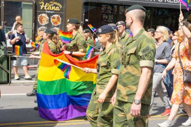 Oslo, Norveç - 28 Haziran 2025: Sivil ve Norveç Silahlı Kuvvetleri üyeleri gökkuşağı bayraklarıyla bir geçit törenine katıldılar