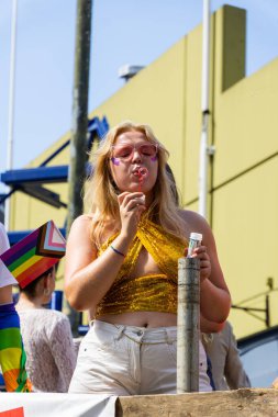 Oslo, Norveç - 28 Haziran 2025: Güneş gözlüklü kadın Oslo, Norveç 'te canlı bir Onur Yürüyüşü' nde baloncuk üflüyor