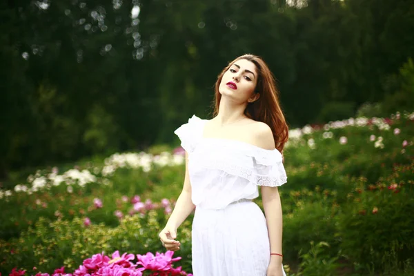 Bella ragazza con fiori di peonie — Foto Stock
