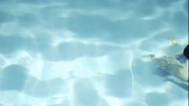 Aerial view of girl swimming underwater in a swimming pool