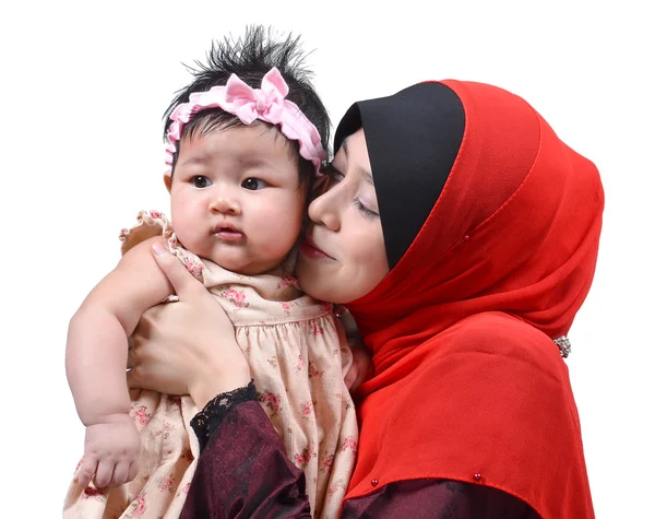 Ung asiatisk muslimska mamma kysser henne söt baby flicka isolerad på vit bakgrund — Stockfoto