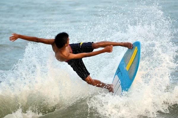 KUANTAN - 29 DECEMBRIE: surfer neidentificat in actiunea de capturare a valurilor seara la plaja Teluk Cempedak pe 29 decembrie 2012 in Kuantan, Pahang, Malaezia . — Fotografie, imagine de stoc