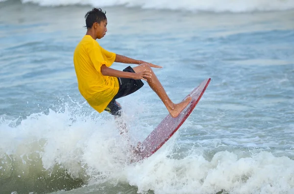 KUANTAN - 29 DECEMBRIE: surfer neidentificat in actiunea de capturare a valurilor seara la plaja Teluk Cempedak pe 29 decembrie 2012 in Kuantan, Pahang, Malaezia . — Fotografie, imagine de stoc