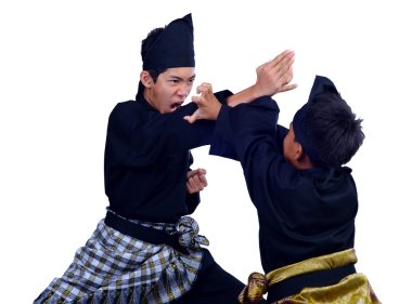 İki malay Asya genç erkek fikir tartışması bir pencak silat, Malay geleneksel disiplin savaş sanatı beyaz arka plan üzerinde izole