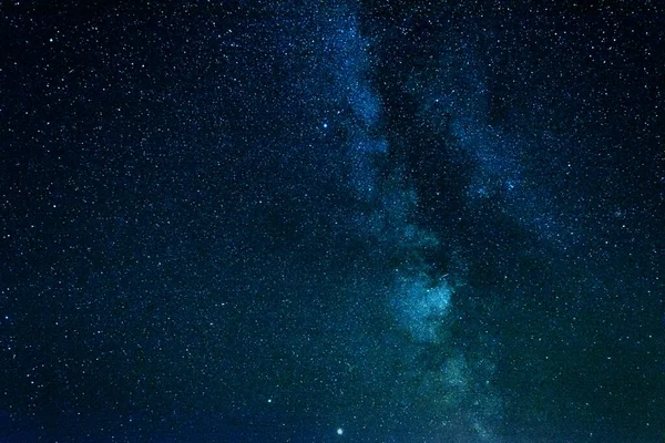 Açık gece gökyüzü Samanyolu ve büyük miktarda yıldızla.