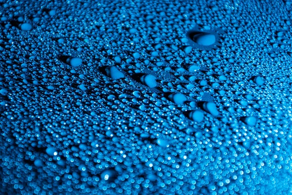 Πολύχρωμο αφηρημένο φόντο με σταγόνες νερού φωτίζεται με μπλε φως LED. — Φωτογραφία Αρχείου