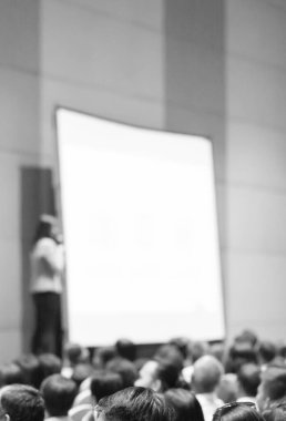 Sözcü bir şirket iş konferansında konuşma yapıyor. Seyirciler sunucu önünde sunucuyla salonda. Şirket yöneticisi iş ve girişimci semineri sırasında konuşma yapıyor.