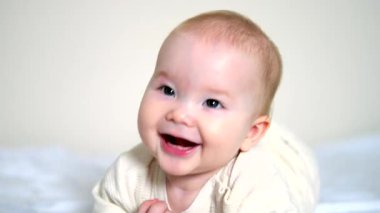Yatakta uzanmış gülümseyen bir bebek, yakın plan çekimde yakalandı. Sıcak ev atmosferi, doğal duygular, erken gelişim. Aile, sağlık, ebeveynlik ve eğitim kullanımları için harika.