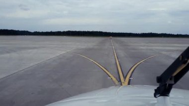 Havaalanı taksisi boyunca taksicilik yapan küçük bir uçağın kokpit görüntüsü. İleride bir servis aracı var. Olay yeri havacılık atmosferini ve uçuş öncesi operasyonları yakalıyor..