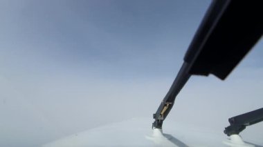 POV kokpit görüntüsü: uçak yoğun beyaz bulutların içinden geçer, karanlık bir buluttan parlak güneş ışığına çıkar. Değişen koşullarda uçmanın gerçek birinci şahıs deneyimi.