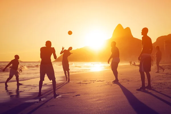 Silhouette di gente del posto che gioca a palla al tramonto a Ipanema Beach, Rio de Janeiro, Brasile — Foto Stock