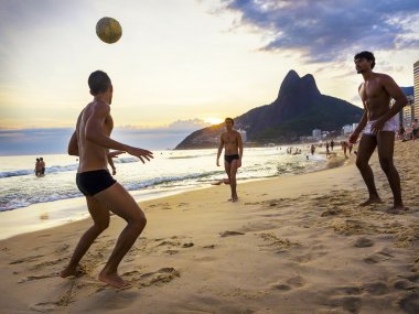 Yerliler top oynamak batımında Ipanema Plajı, Rio de Janeiro, Brezilya içinde