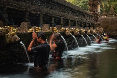 Endonezya 'nın Bali kentindeki Tampaksiring kasabası yakınlarındaki Tirta Empul Tapınağı' nda namaz kılan ve banyo yapan Balili Hindu Hindu..