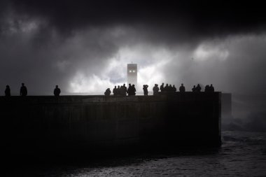 İnsanlar siluetleri üzerinde fırtına görmek deniz İskelesi