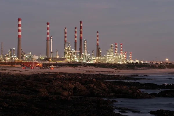 Olieraffinaderij in de buurt van de zee in de schemering — Stockfoto