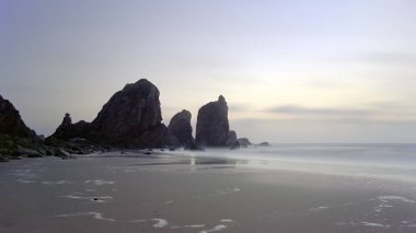 Alacakaranlıkta uzak kayalık plajda. Uzun mesafe. Portekiz. Analog: 35 mm film.