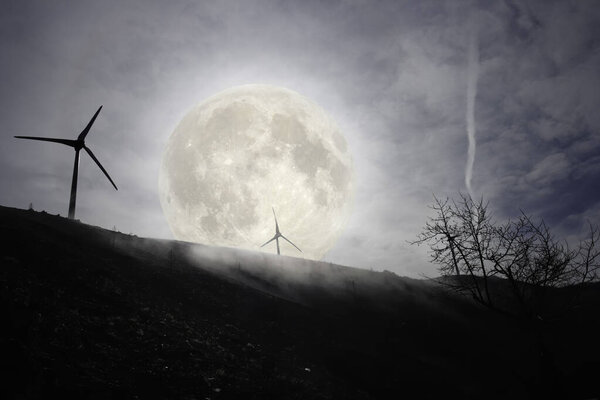 Full moon in a mountain with wind turbines