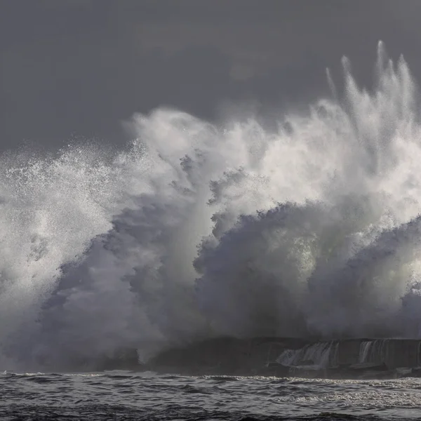 Stormy wave splash. Ave river mouth pier and beacon, Vila do Conde, north of Portugal.