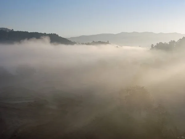 Mountain at dawn with clouds, fog light rays and trees. Peneda Geres National Park at dawn.