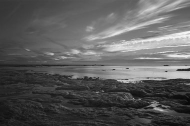 Alacakaranlıkta siyah beyaz deniz manzarası. Kuzey Portekiz kayalık kıyıları.