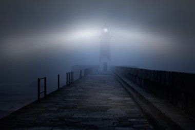 Lighthouse in a foggy night clipart