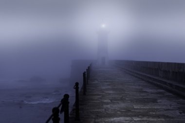 Lighthouse in a foggy night clipart