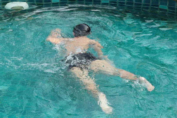 Um menino nadando na piscina . — Fotografia de Stock