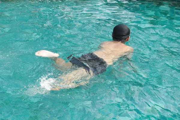 Un garçon nage dans la piscine. — Photo