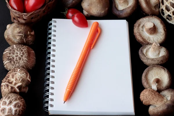 Book notes and fresh mushroom is background — Stock Photo, Image