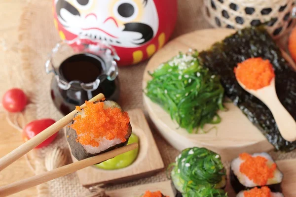 Rolo de sushi com salada de algas e ovos de camarão — Fotografia de Stock