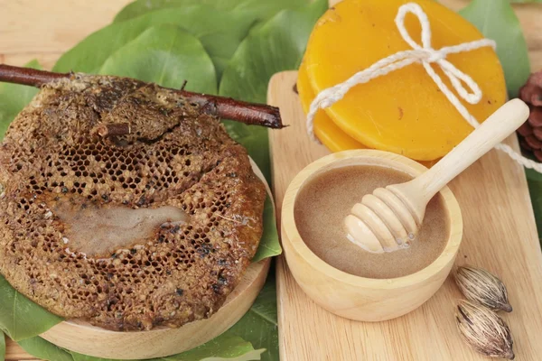 Miel con panal y cera sobre hojas verdes —  Fotos de Stock