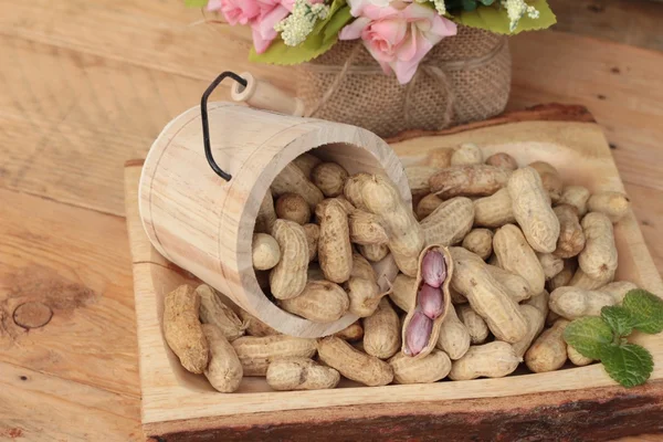 Cacahuetes y cacahuetes cocidos sobre fondo de madera . — Foto de Stock