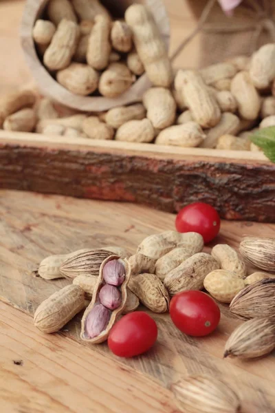 Peanut and boiled peanuts on wood background. — Stock Photo, Image