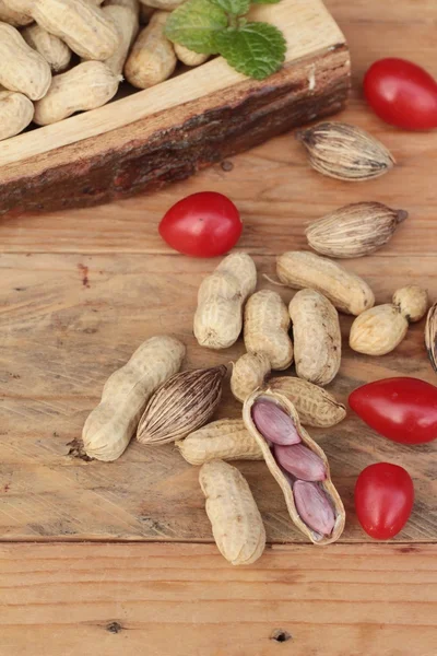 Cacahuetes y cacahuetes cocidos sobre fondo de madera . — Foto de Stock